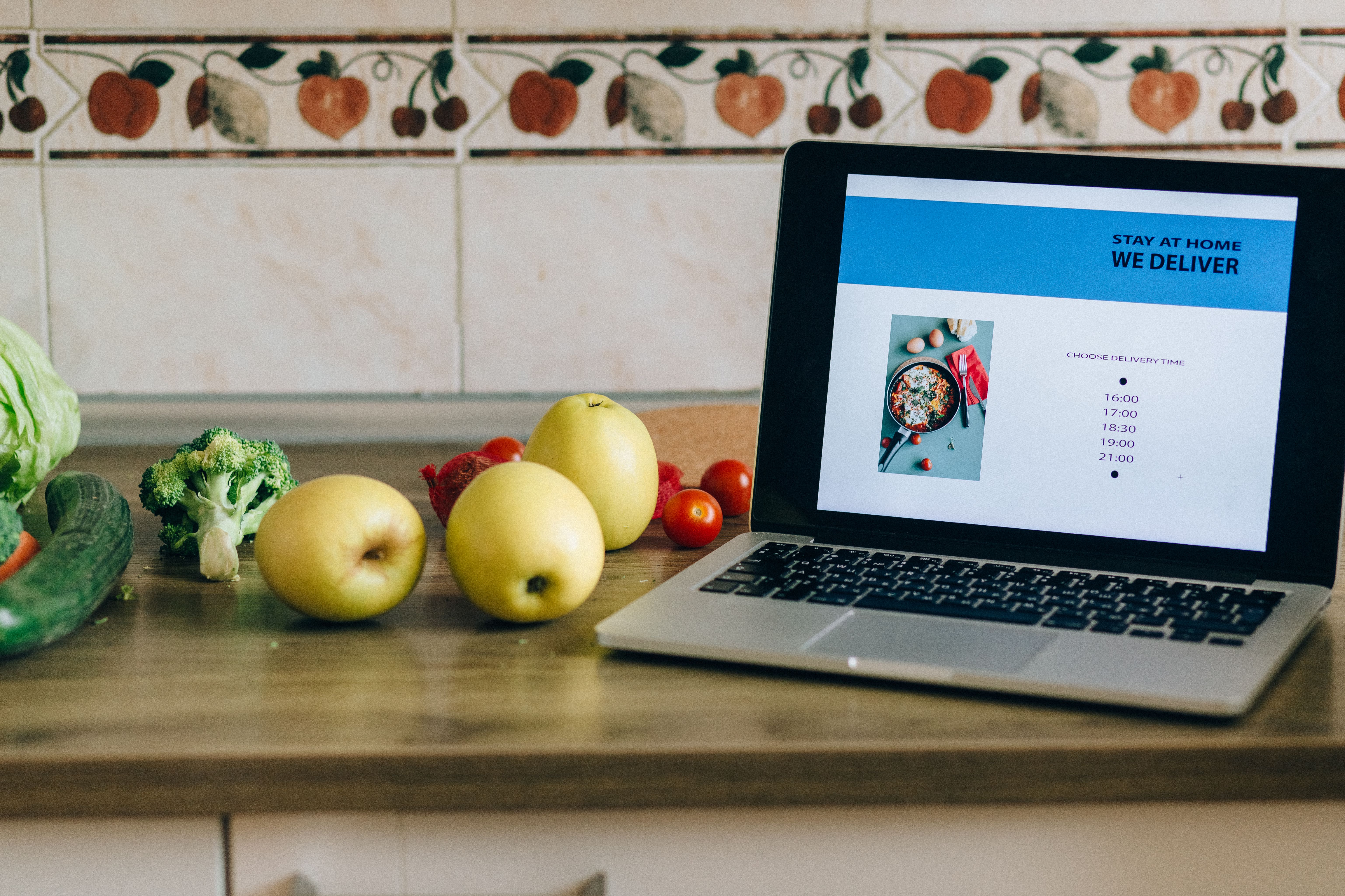 A restaurant ordering website displayed on a laptop beside fresh ingredients